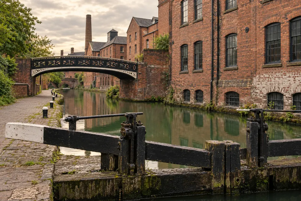 Brick industrial buildings and a lock beside a Birmingham-style canal